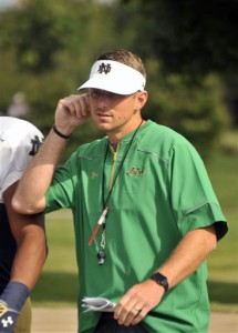 In this Saturday, Aug. 15, 2015, photo, Notre Dame offensive coordinator Mike Sanford walks onto the practice field during an  NCAA college football practice in South Bend, Ind. Sanford is Notre Dame's new offensive coordinator but what exactly does that mean for the promising 33-year-old assistant. Fighting Irish coach Brian Kelly has always had an hands on approach with his offense and quarterbacks, and two of Kelly's former offensive coordinators are still on staff.  (AP Photo/Joe Raymond)