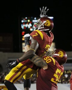 Southern California wide receiver Steven Mitchell, top, celebrates his touchdown against Arkansas State with guard Toa Lobendahn during the first half of an NCAA college football game, Saturday, Sept. 5, 2015, in Los Angeles. (AP Photo/Danny Moloshok)
