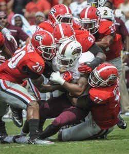FILE - In this Sept. 5, 2015, file photo, Louisiana Monroe running back DeVontae McNeal (28) is brought down by Georgia safety Quincy Mauger (20), defensive lineman John Atkins (97), and linebacker Davin Bellamy (17) during the first half of an NCAA college football game,  in Athens, Ga. (AP Photo/John Amis, File)