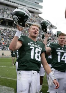 Michigan State quarterback Connor Cook (18) celebrates with teammates following a 35-21 win over Air Force in an NCAA college football game, Saturday, Sept. 19, 2015, in East Lansing, Mich. At right is Brian Lewerke (14). (AP Photo/Al Goldis)