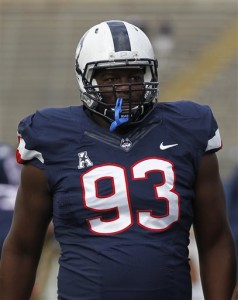 Connecticut defensive lineman Foley Fatukasi (93) stands on the sideline prior to an NCAA college football game against Navy, Saturday, Sept. 26, 2015, in East Hartford, Conn. Three years after Superstorm Sandy forced his family from their home, Connecticut's Fatukasi has settled into a central part of the Huskies defensive line. (AP Photo/Stew Milne)
